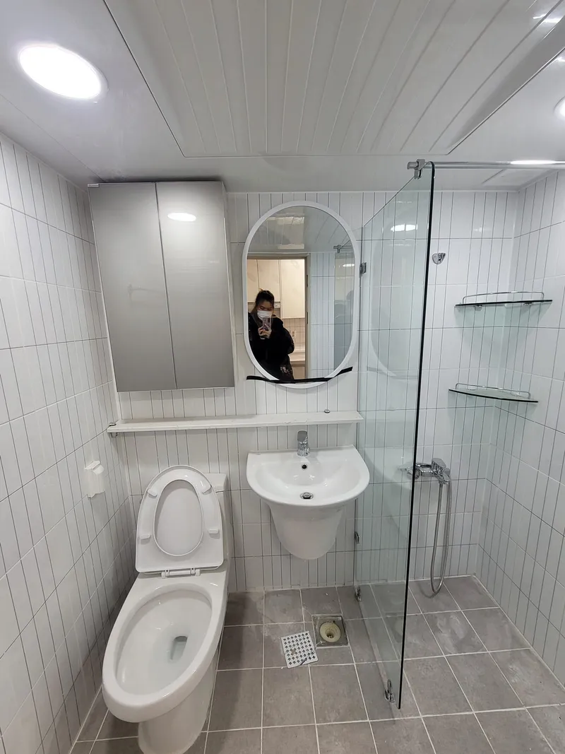거울장과 세면대를 단 흰 욕실