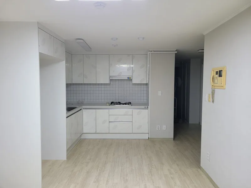 주방 상하부장과 타일 벽 및 냉장고장