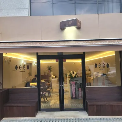 간판을 단 카페 외관과 나무 벤치