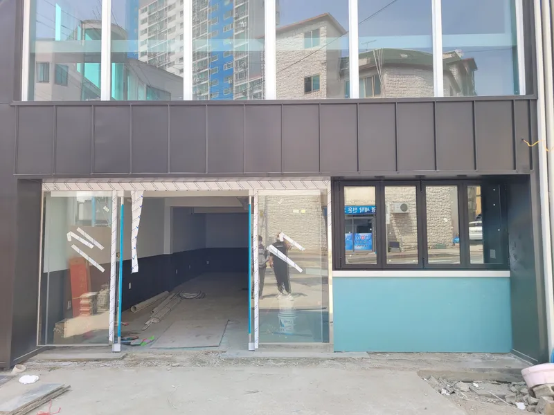 1층 출입문과 하늘색 벽 아래 창