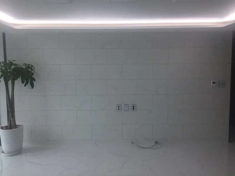간접조명과 흰 대리석 무늬 벽 거실